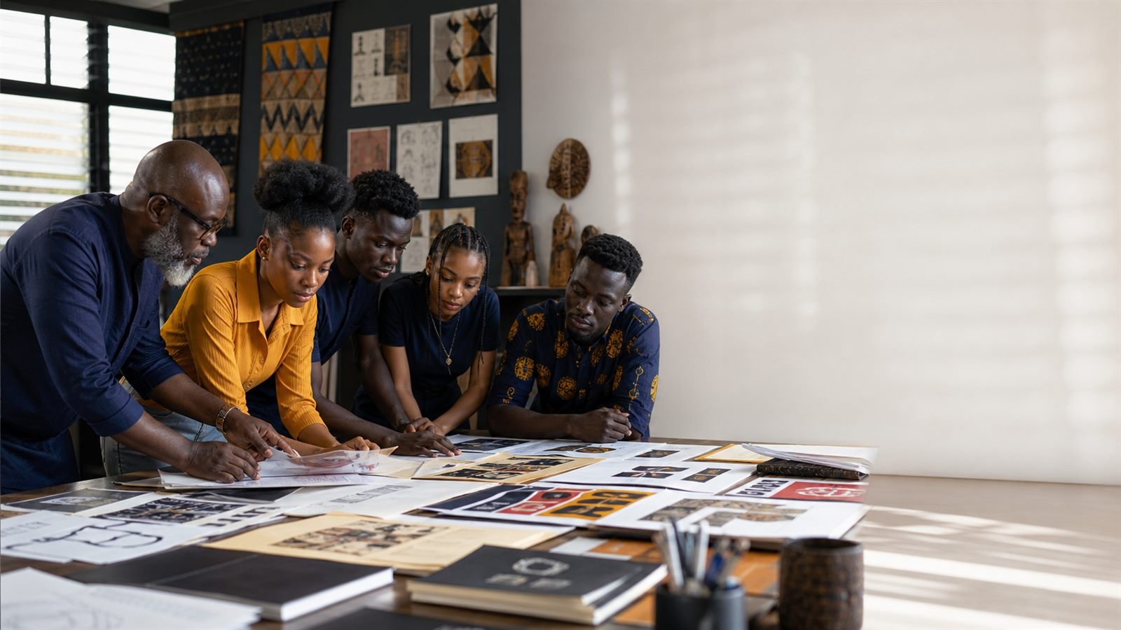 Black lecturers and students reviewing archival design work.
